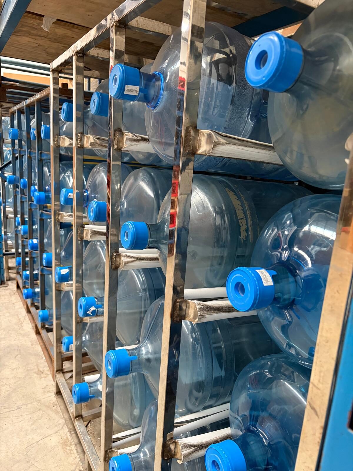 Racks of mains-fed and bottled water cooler refills held in stock at LC Vending Solutions.